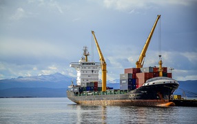 Large cargo ship with containers leaves for voyage
