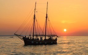 Большой корабль с опущенными парусами на закате солнца 