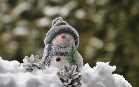 Snowman figurine with pine cones in winter