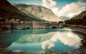 Старый кирпичный мост на озере у горы,Франция