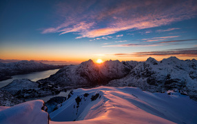 Красивый вид на заснеженные горы в лучах солнца на рассвете, Норвегия