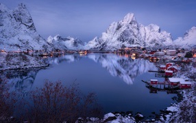 Snow-capped mountains by the lake at dusk, Lofoten Islands. Norway