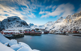 Snow-covered mountains by the lake with houses, Lofoten Islands