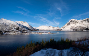 Покрытые снегом горы под голубым небом у воды, Норвегия