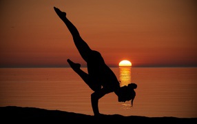A girl doing yoga at sunset