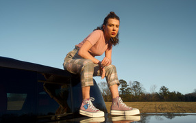 Актриса Милли Бобби Браун сидит на машине в кедах