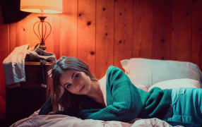 Актриса  Виктория Джастис в зеленом свитере на кровати