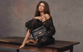 Американская актриса и певица Зендая в черном платье на столе