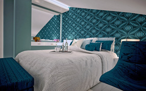 Спальня с большой серой кроватью и красивыми стенами