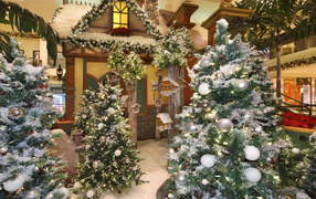 Christmas trees stand in a room with decor