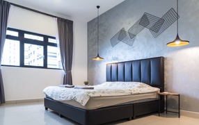 Пустая спальная комната с большой кроватью у окна 