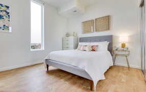 Высокое окно в спальне с большой кроватью 