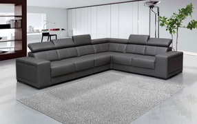 Large black corner sofa in a room with white walls