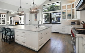 Large granite table in the kitchen with white furniture