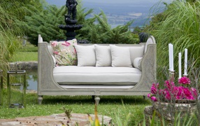 Large gray sofa in the garden by the pond