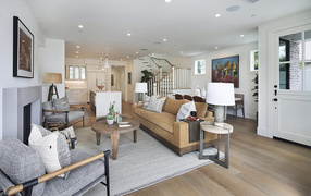 Большая гостевая комната с мебелью и лестницей на второй этаж