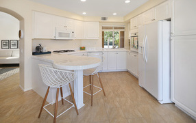 Large refrigerator and white furniture in the kitchen