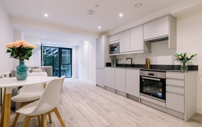 Большая просторная белая гостиная с букетом роз