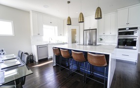Leather armchairs in a large kitchen with white walls