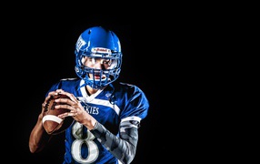 Мужчина игрок в американский футбол на черном фоне