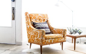 Старое кресло с подушкой в комнате 