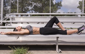 Спортивная девушка загорает на солнце 