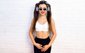 Sporty girl with glasses near the wall