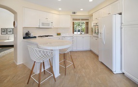White stylish furniture with a large refrigerator in the kitchen
