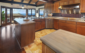 Деревянная мебель на кухне с окнами с видом на море