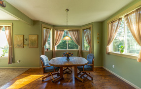 Деревянный стол стоит в гостиной с зелеными стенами