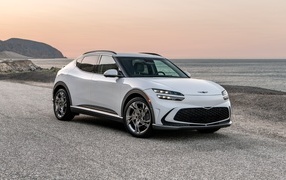 Белый автомобиль Genesis GV60, 2023 года на пляже
