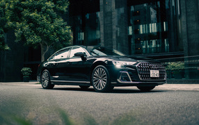 Черный автомобиль Audi A8 L 60 TFSI Quattro у здания