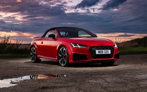 Красный автомобиль Audi TTS Final Edition Roadster 2023 года на фоне неба
