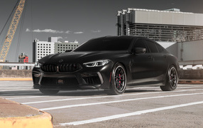 Черный автомобиль BMW M8 на стройке