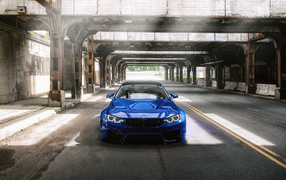 Синий автомобиль BMW M4 под мостом