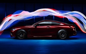 Бордовый автомобиль BMW M8 Competition оптекает волнами