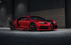Красный автомобиль Bugatti Chiron CGI у кирпичной стены