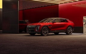 Красный электрокар Cadillac Lyriq Sport 2024 года на заправке