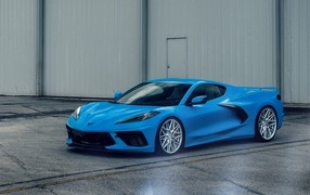 Синий Chevrolet Corvette C8 у серого здания