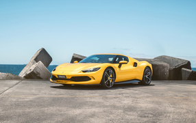 Желтый автомобиль Ferrari 296 GTB у камней