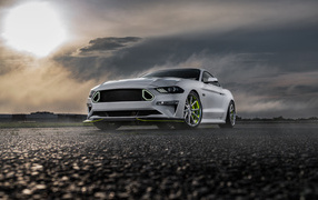 Silver Ford Mustang GT against a stormy sky