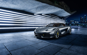 Серебристый автомобиль Koenigsegg Gemera на фоне города