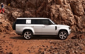 White SUV Land Rover Defender 130 in the mountains