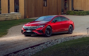 Красный автомобиль Mercedes-AMG EQS 53 4MATIC+  у дома