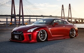 Красный автомобиль Nissan GTR 35R на фоне моста