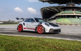 Гоночный автомобиль Porsche 911 GT3 RS Weissach Package 2023 года на трассе