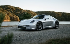 Серебристый автомобиль Porsche 911 ST 2023 года у воды