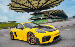Желтый гоночный автомобиль Porsche 718 Cayman GT4 RS