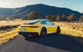 Желтый автомобиль Porsche 911 Carrera GTS вид сзади