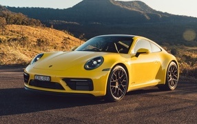 Желтый быстрый автомобиль Porsche 911 Carrera GTS вид спереди